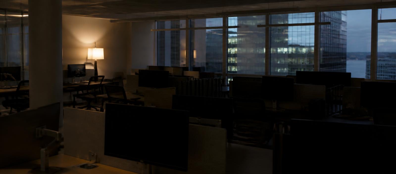 An empty sales floor at dusk with one lamp still on