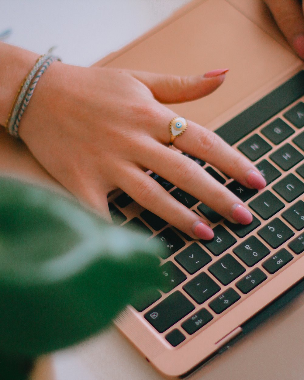 A social media manager typing on a laptop at a desk with a content calendar open