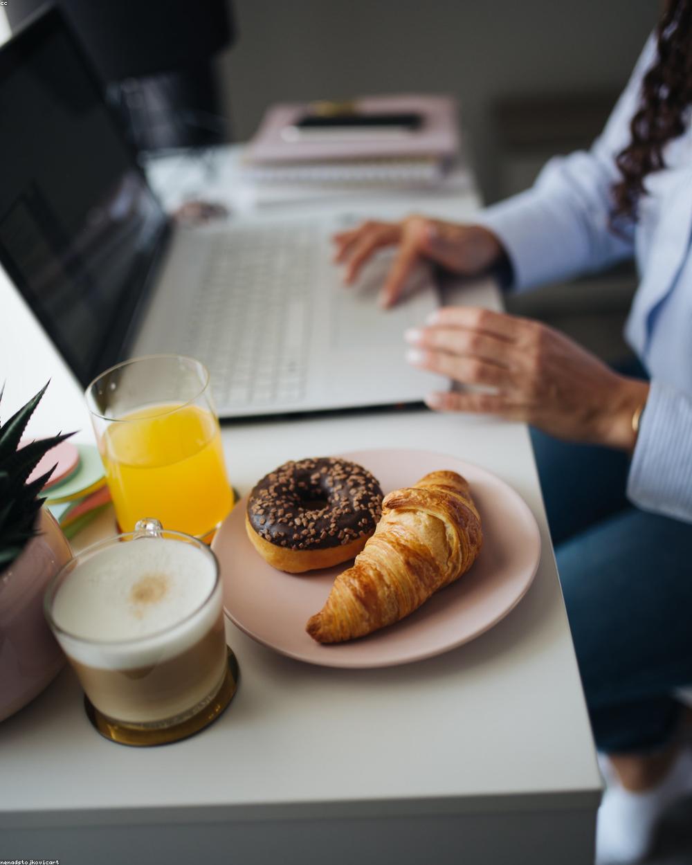 A support lead at a laptop scanning a crowded inbox before the day's shift starts