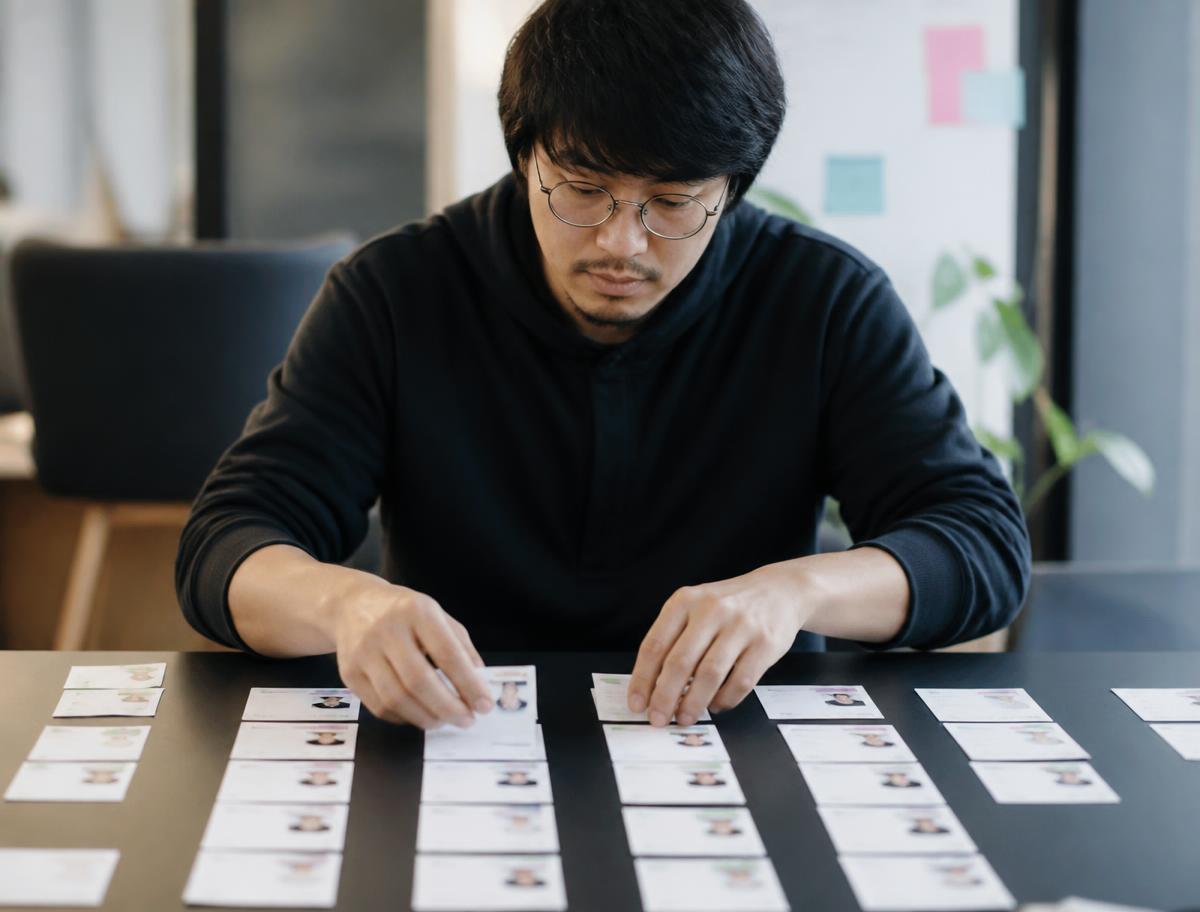 An analyst grouping customer profile cards into columns on a table