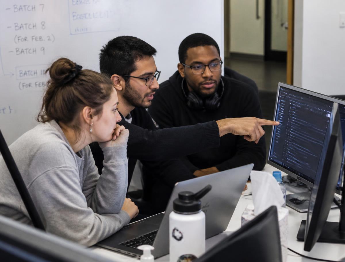 A small team reviewing flagged emails together at a shared desk