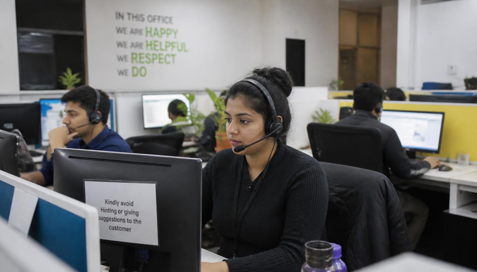 A call center style office with agents at desks handling messages under soft overhead light