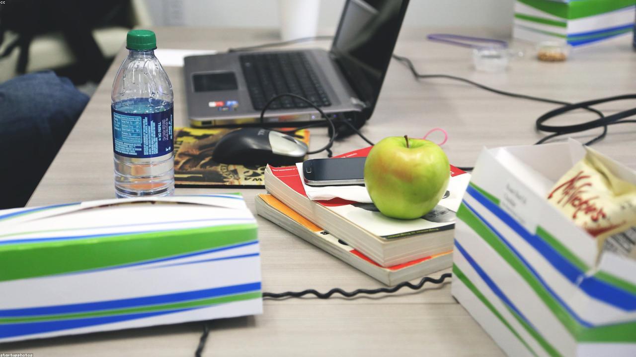 An analyst's desk with a notebook of data-quality notes beside an open laptop